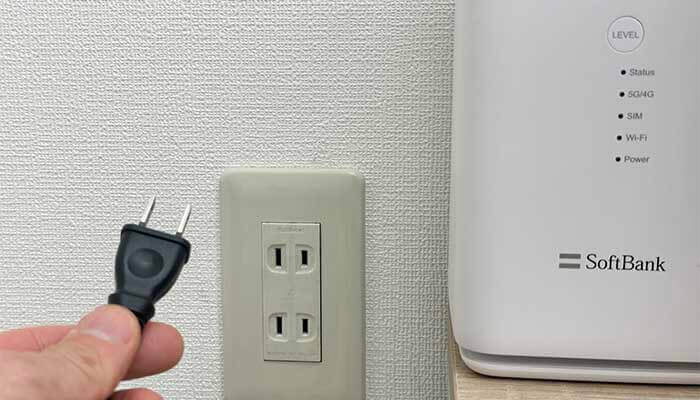 コンセントからホームルーターのACプラグをぬいている写真