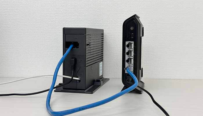ONUと無線ルーターのLANケーブルの抜き差しをしている写真