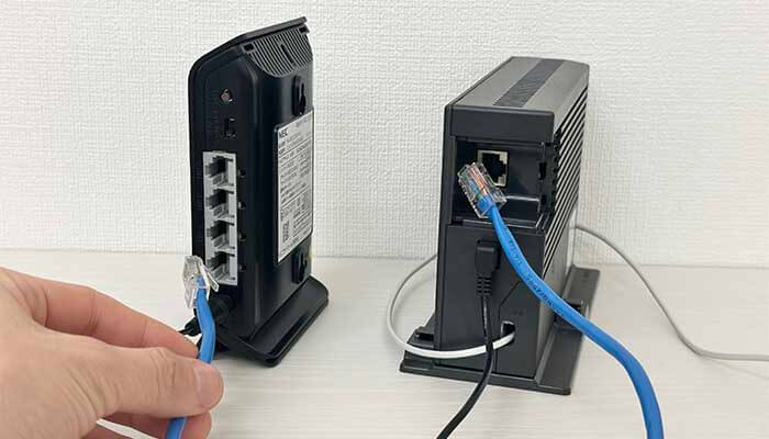 ONUと無線ルーターからLANケーブルを抜いている写真